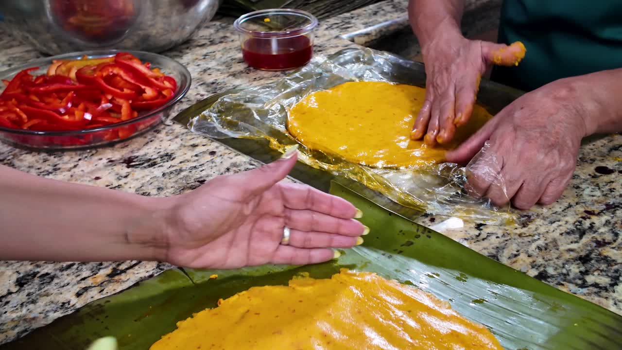 Mani che preparano la tradizionale pasta gialla su una foglia di banano