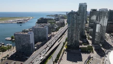 drone flying along the gardiner expressway next to lake ontario and billy bishop airport in toronto