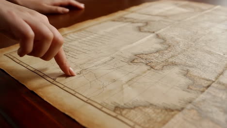 person pointing at an old map