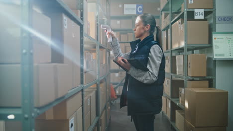 warehouse worker scanning inventory and checking temperature