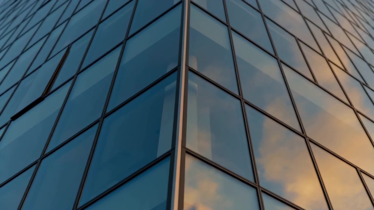 Perspectiva contrapicada que muestra la esquina de una moderna torre de oficinas de cristal con paneles de muro cortina que reflejan un cielo frío y nubes cálidas, montantes nítidos, bordes definidos y un elegante diseño urbano corporativo.