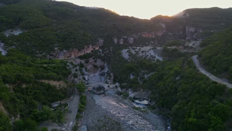 beautiful rocky landscape with a medieval bridge from a bird's eye view at sunset