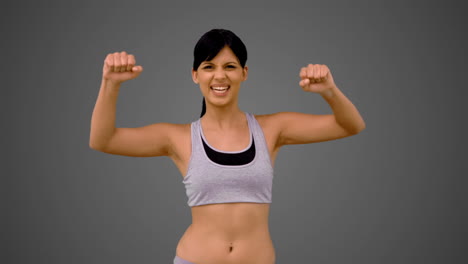 bruneta en forma tensando sus brazos y sonriendo