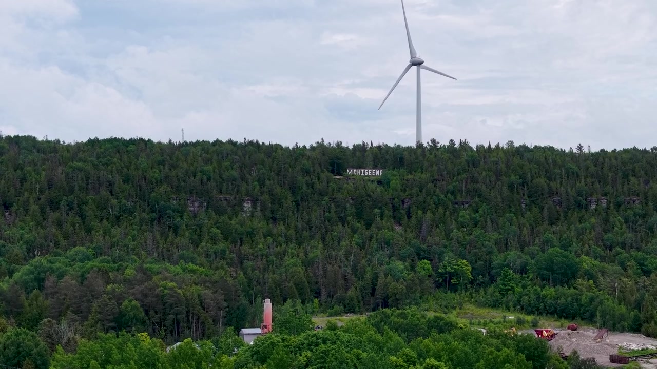 Cinematic aerial footage captures a wide mosaic of trees open land and northern Canadian terrain during clear daytime conditions