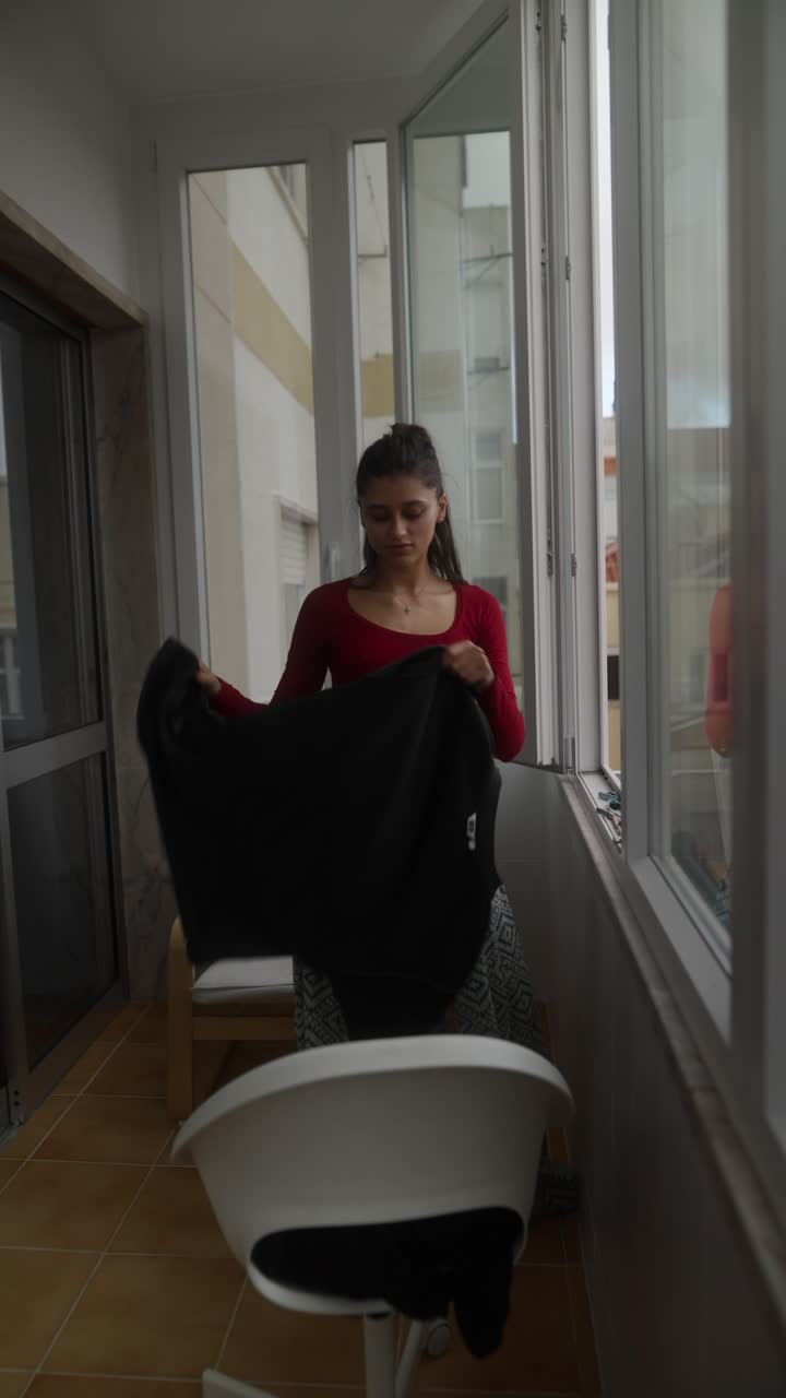 Donna che stende il bucato su un balcone