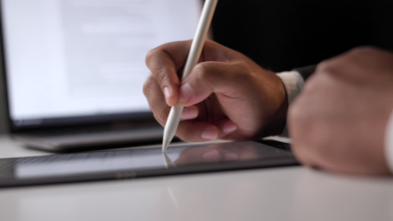 Close up businessman hand working electronic Signature on Tablet by Stylus at night. Write business agreement of contract. Man signing contract on tablet. Business and technology concept.