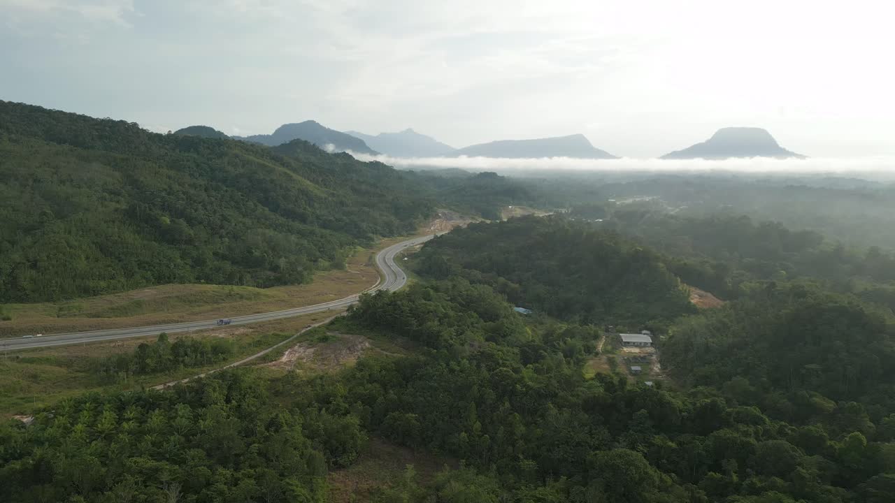 Foggy Sunset Early Morning During Raining Season Asian Tropical Rain forest, with Mountain And Green Valley,Palm Oil Farm,Sarawak,Borneo.
