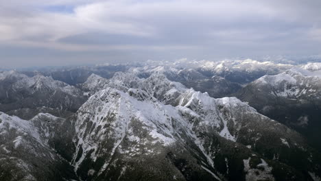 flying over snowy mountains in winter day. aerial