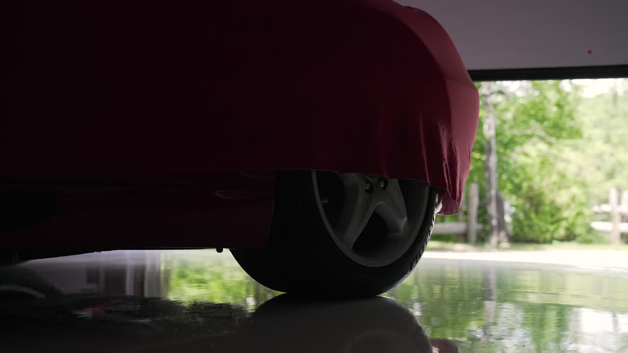 빨간색으로 인 스포츠카를 드러내는 전기 차고 문을 열고