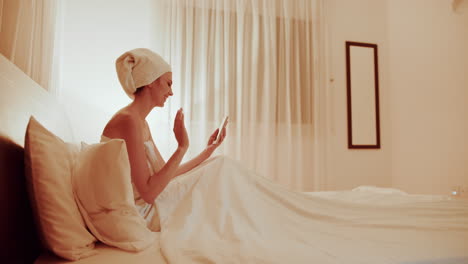 woman relaxing in bed with tablet