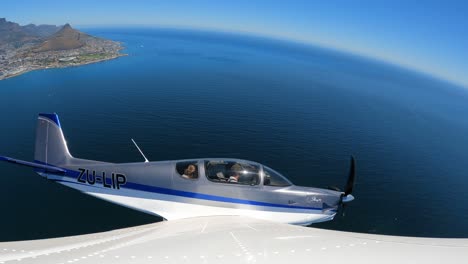 avión vuela sobre el océano atlántico revelando la montaña de la mesa y la ciudad