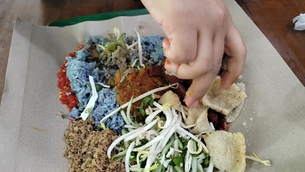 Nasi Kerabu, a traditional Malay dish from Kelantan, Malaysia, featuring blue rice, fresh herbs, and succulent grilled meat.