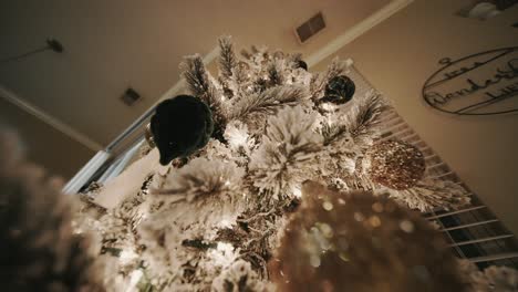 Empuje-Hacia-Arriba-La-Foto-De-Un-árbol-De-Navidad-Cubierto-De-Nieve-Que-Muestra-Todos-Los-Adornos-Y-Luces-Que-Hay-En-él.