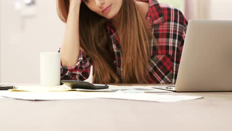 Pretty-brunette-with-calculator-paying-bills