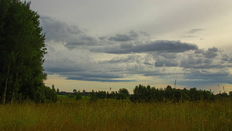 cinematic time lapse of a sunrise over a grassy field with dramatic cloud movement in the sky, time lapse