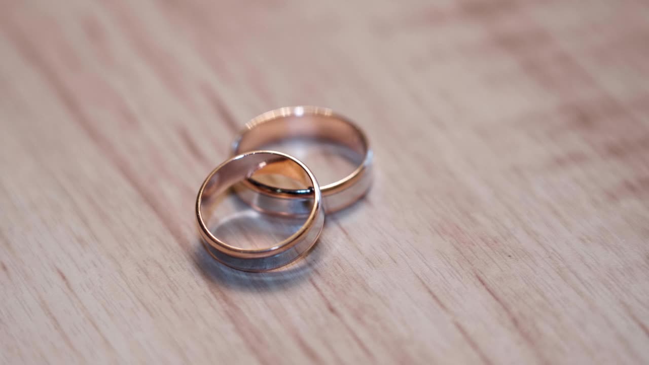 Wedding rings and play with the light on the wooden background