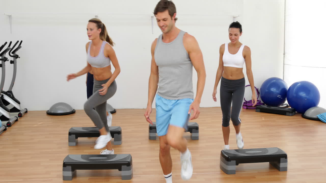 clase de aeróbicos dando pasos y aplaudiendo juntos