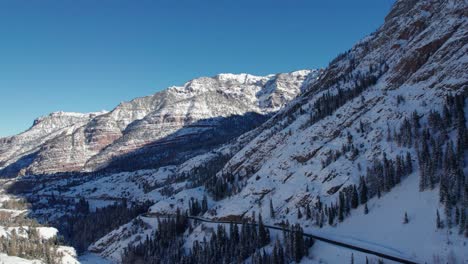 Aerial-drone-view-revealing-a-large-mountainside-and-highway