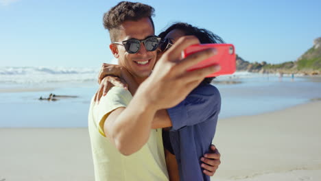 una pareja tomando una selfie en la playa.