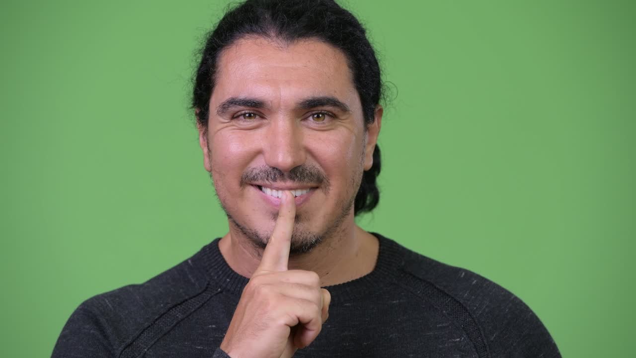 hombre guapo con el dedo en los labios