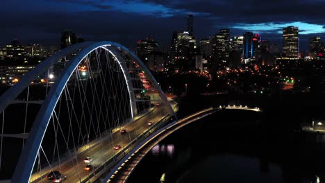 aerial drone view of the edmonton walterdale bridge over the north saskatchewan river during a summer night and the downtown skyline in the background