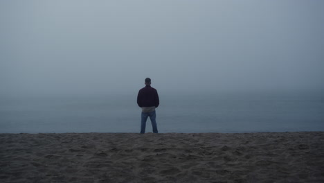 thoughtful guy standing sea beach. relaxed man enjoying morning ocean landscape