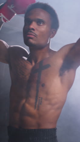 Vertical-Video-Of-Tattooed-Male-Boxer-Wearing-Gloves-Entering-Ring-Before-Start-Of-Boxing-Match-Waving-And-Greeting-Fans