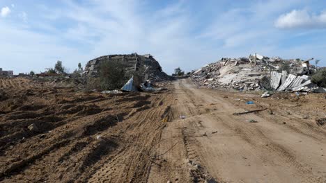 a dirt road in gaza has been churned up by all the vehicles that have passed