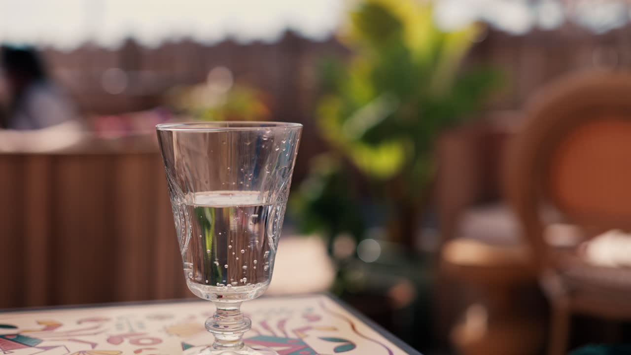 Close up of a glass of sparkling water on a white table and a blurred background