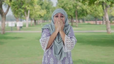 happy muslim woman getting a surprise in park