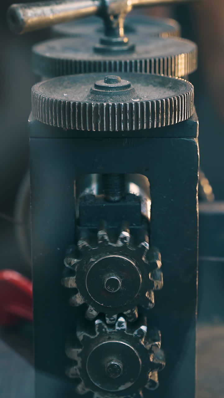 CU: young silversmith processes long metal silver cable with forge-rolling machine tool at workplace in workshop close view