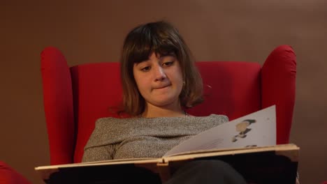 primer plano de una niña leyendo un libro de navidad.
