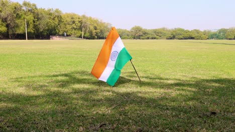 indian tricolor national flag waving at green playing ground at day from flat angle