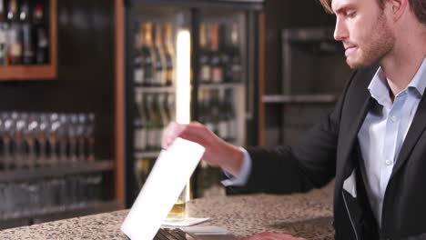 smiling businessman typing on his laptop while drinking