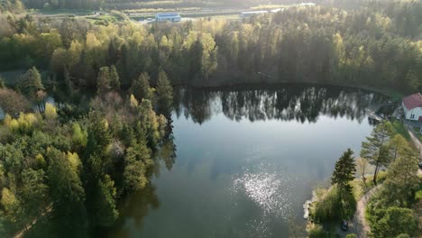 A-small,-picturesque-lake-nestled-in-the-heart-of-a-vast-forest,-seen-from-a-bird's-eye-view