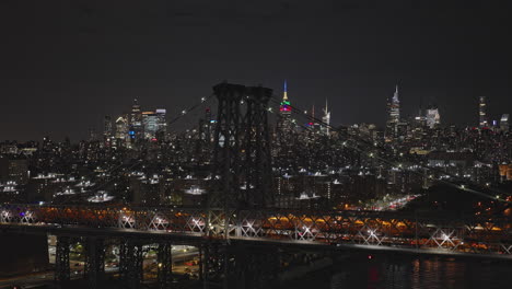 NYC-New-York-Aerial-v302-tracking-flyover-East-river,-capturing-traffic-on-Williamsburg-bridge,-East-Village-and-downtown-night-cityscape-of-Midtown-Manhattan---Shot-with-Inspire-3-8k---September-2023