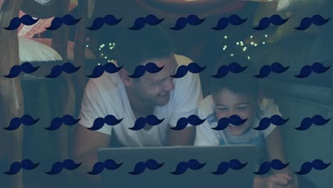 Animation-of-multiple-moustache-icons-in-seamless-pattern-over-caucasian-father-and-son-using-laptop