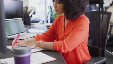 Mujer-De-Negocios-Birracial-Escribiendo-Y-Usando-Computadora-En-La-Oficina,-Cámara-Lenta