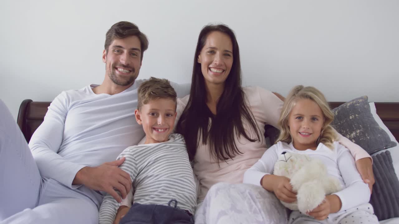 familia sentada juntos en el dormitorio en casa 4k