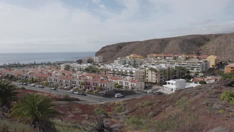 a village, the ocean, cliffs and a rocky coast on a sunny day in palmar, tenerife, canary islands, spain.