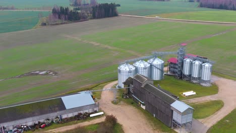 Silos-De-Grano-Modernos-En-Una-Enorme-Granja-Rodeada-De-Campos-Agrícolas,-Vista-Aérea