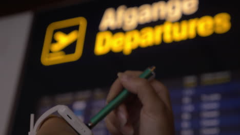 Woman-with-smart-watch-at-flight-information-display