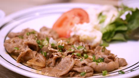 Eating-stir-fried-spicy-beef-seasoned-with-garlic,-spices,-and-green-peppers,-along-with-some-side-dishes-and-rice