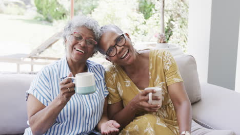 Retrato-De-Felices-Amigas-Afroamericanas-Mayores-Tomando-Café-En-La-Sala-De-Estar,-Cámara-Lenta