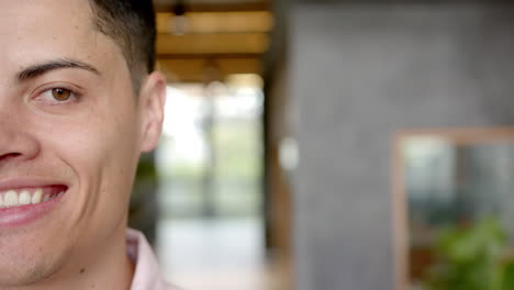 smiling young man with blurred background in modern indoor setting, copy space