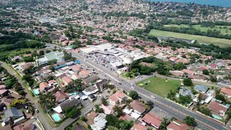 Imágenes-Aéreas-De-Un-Dron-Volando-Sobre-Casas-Residenciales-Con-Vistas-A-Una-Carretera-Muy-Transitada-Con-Tráfico-En-Movimiento-En-Un-Suburbio-De-Yellow-Wood-Park-En-Durban