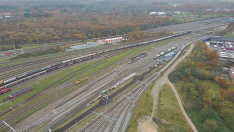 aerial of a long cargo train driving slowly over railway