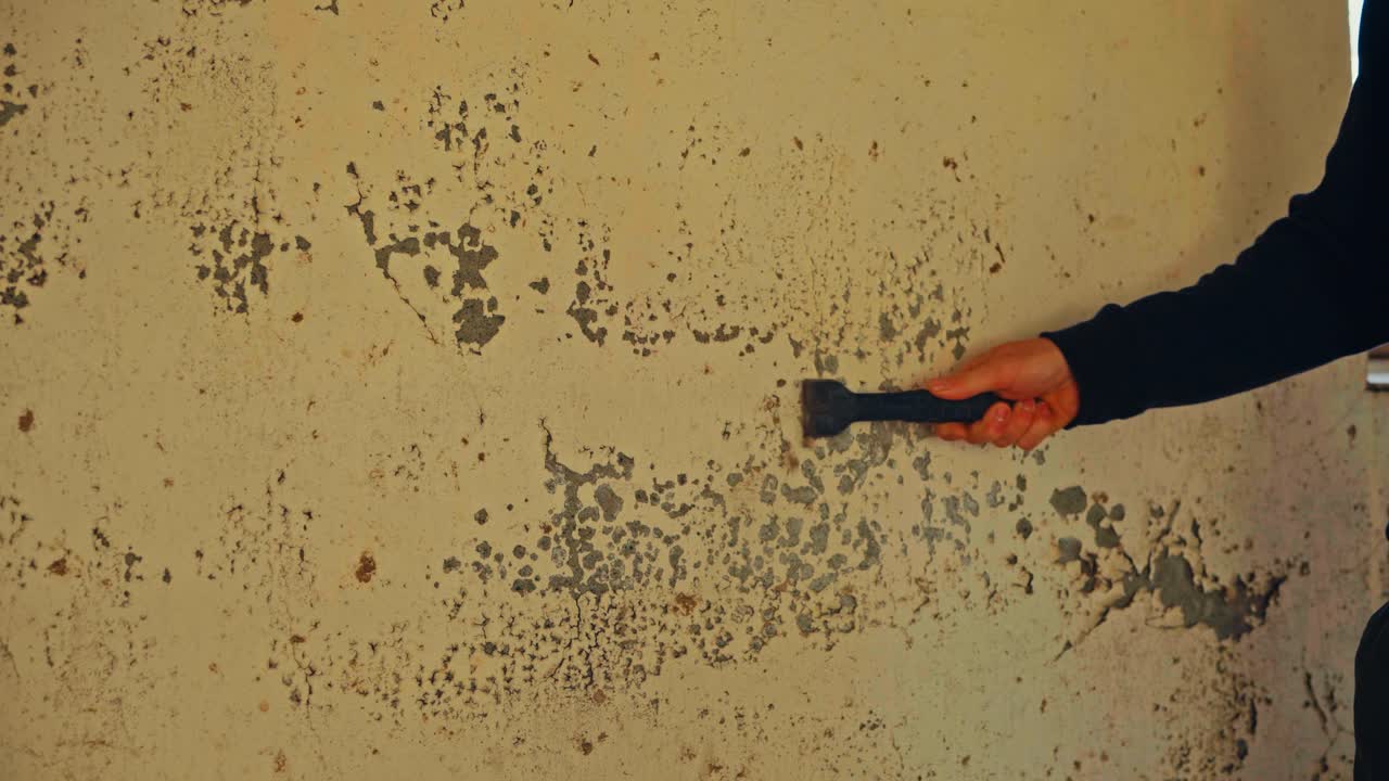 Man Scraping Old Paint From Wall - Close Up