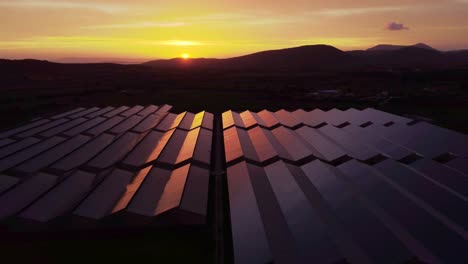 establisher aerial view of large solar panel power station at sunset