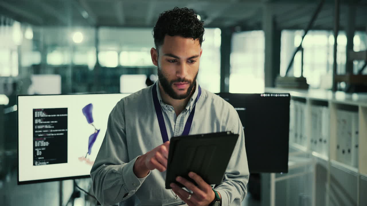 Man in a modern office working on a tablet.